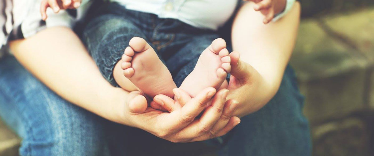 woman holding baby's feet